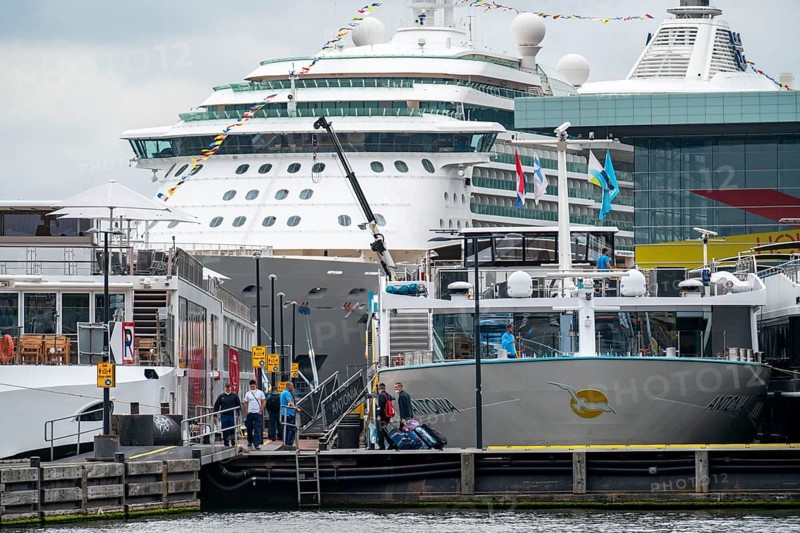River cruise ships at the quay of the Ij, near the main railway station, passengers' luggage being loaded