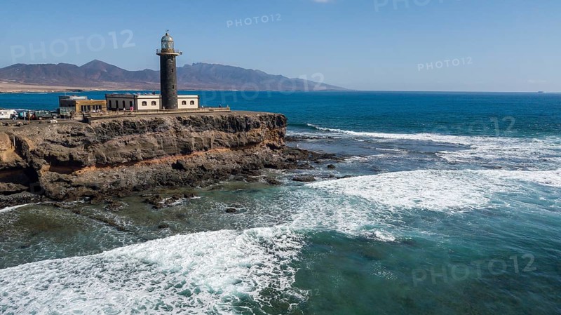 Aerial view of lighthouse Faro Punta de Jandia at southern tip of peninsula Jandia, in the foreground white whitecaps on moving sea swell at reef reef edge onshore sea strong surf, Fuerteventura, Canary Islands, Canary Islands, Spain, Europe