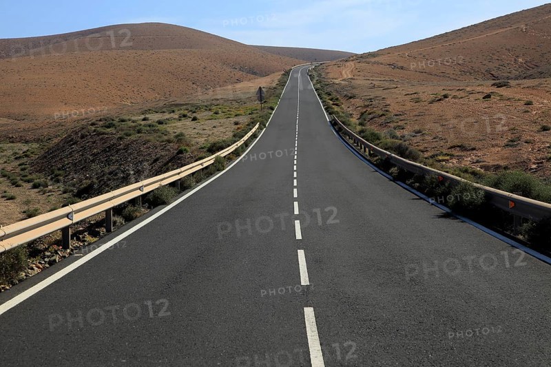 Tarmac road crossing barren desert mountainous land between Pajara and La Pared, Fuerteventura, Canary Islands, Spain, Europe
