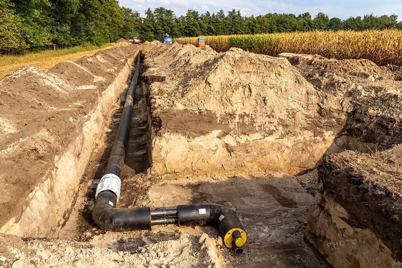 Laying of district heating pipes, next to a field, with maize, the district heating comes from a biogas plant and is fed directly into households in the neighbourhood, private provider, near Delbrück, North Rhine-Westphalia, Germany, Europe
