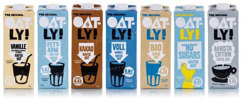 Oatly different types of vegan oat milk cropped against a white background