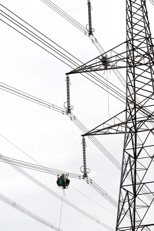 Maintenance work being done on high voltage electricity cables from Sizewell nuclear power station viewed from below looking up towards a pylon, Suffolk, England, United Kingdom, Europe