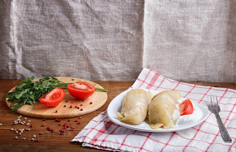 Cabbage rolls with beef, rice and vegetables on a linen tablecloth on a brown wooden background. Homemade