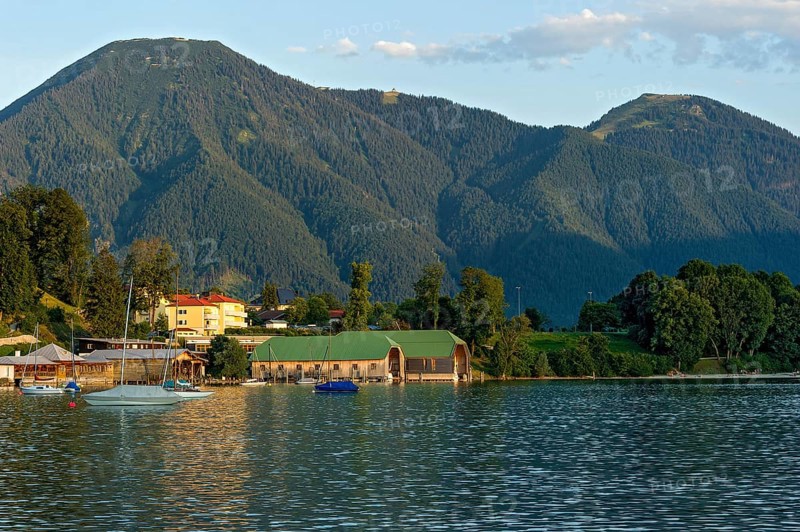 Tegernsee with sailing boats and boat huts, warm evening light, town Tegernsee, mountain Wallberg, Mangfall mountains, Bavarian Prealps, Alps, Upper Bavaria, Bavaria, Germany, Europe