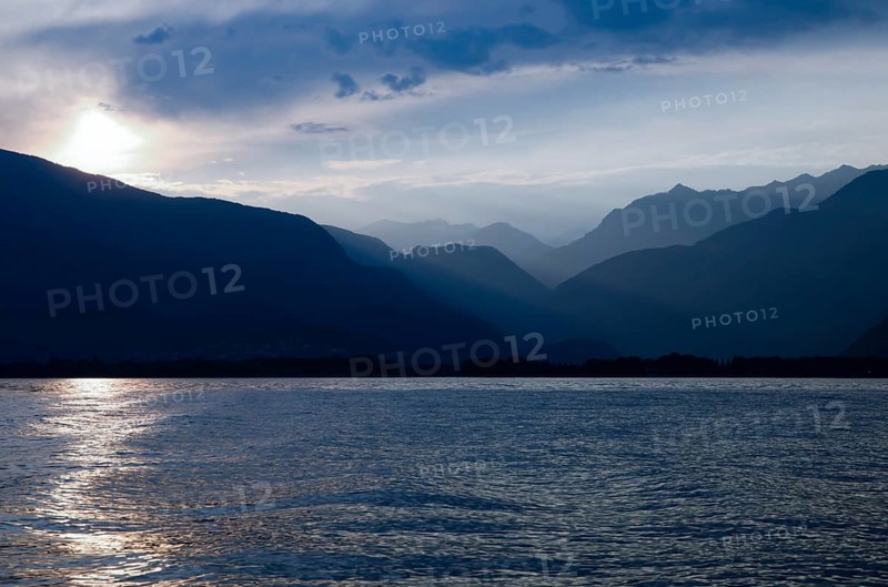 Beautiful Sunset over an Alpine Lake Maggiore with Mountain Range and Sky in Ticino, Switzerland, Europe