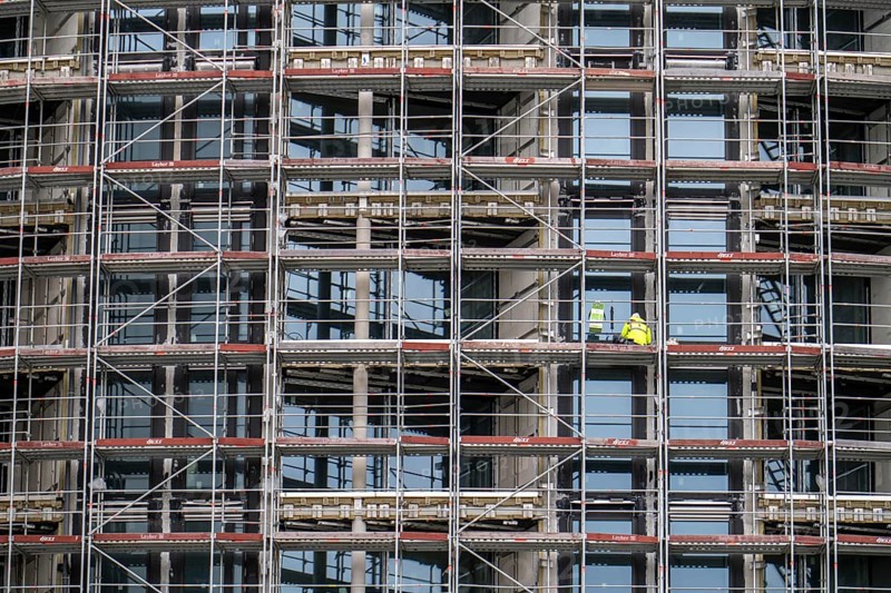 Large construction site, construction of a residential building with many flats, scaffolding, windows are installed, being sealed, grouted, Frankfurt am Main, Hesse, Germany, Europe