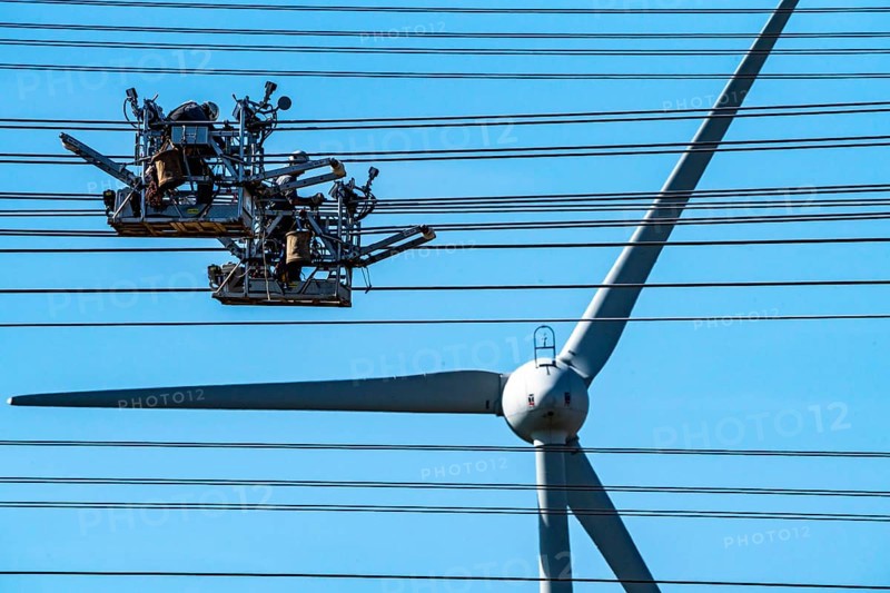 Construction of a new line route, 380 KV extra-high voltage line between Osterath and Gohr, near Neuss, fitters in cable trolleys, on the conductor cables, installing field spacers at great heights, wind power station, North Rhine-Westphalia, Germany, Europe