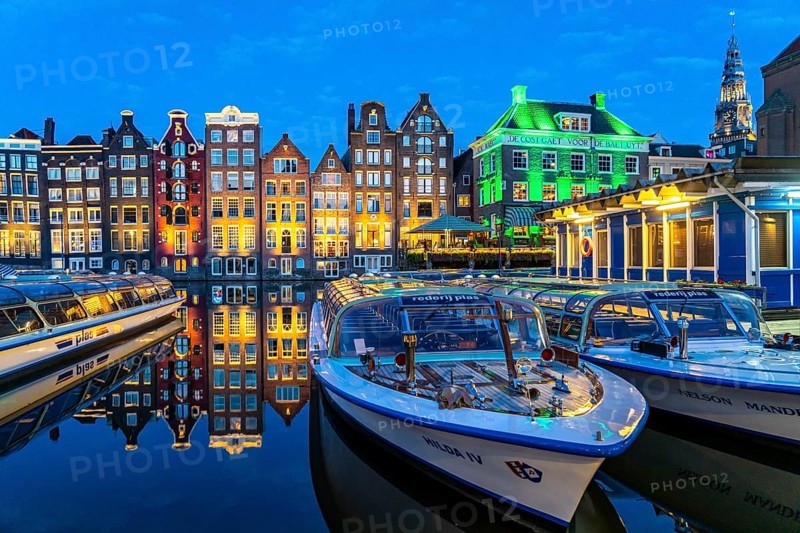 Canal houses on the Damrak, in the centre of the old town of Amsterdam, harbour, starting point of many canal tours, in the evening, church tower of the Oude Kerk, Netherlands