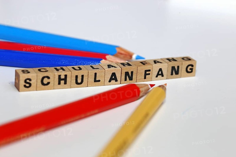 Symbolic image for the start of the new school year with letter cubes and pens