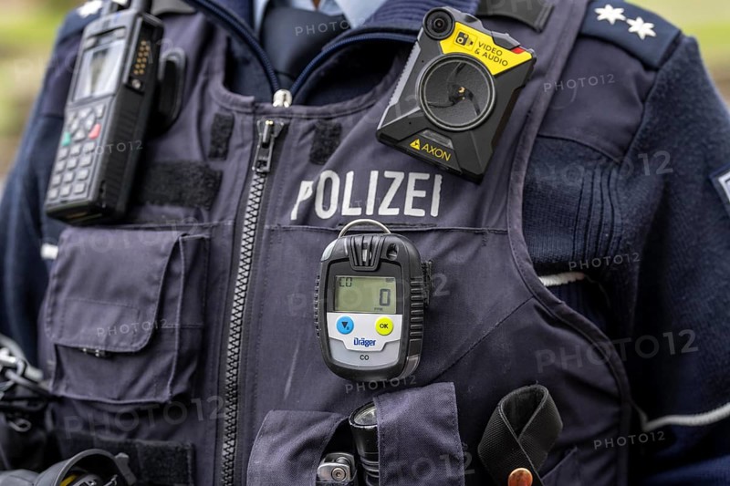 Police, policewoman with equipment waistcoat, CO measuring device device, measures the carbon monoxide content in the air during operations, e.g. in flats, the gas is odourless and has a lethal effect, above a bodycam, North Rhine-Westphalia, Germany, Europe