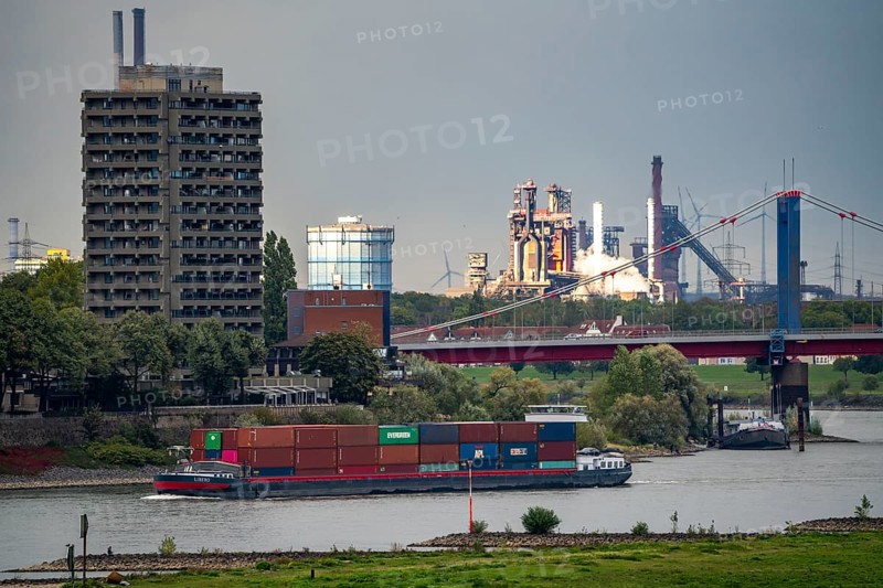 Rhine near Duisburg, bank near Duisburg-Homberg, behind it the Thyssenkrupp steelworks in Duisburg-Bruckhausen, blast furnaces 8 and 9, high-rise building with the Hotel Rheingarten, Friedrich-Ebert-Bridge, Duisburg, North Rhine-Westphalia, Germany, Europe