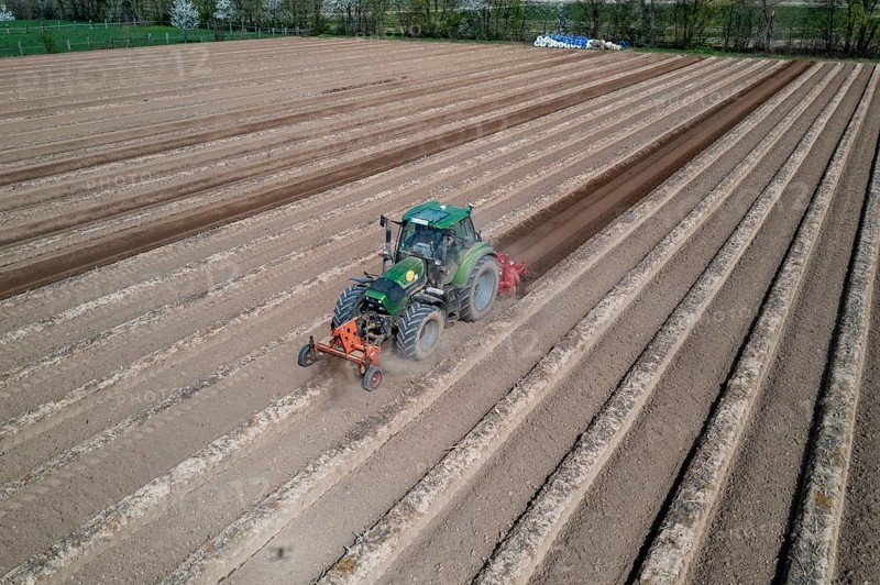A farmer builds asparagus ridges on a field with the help of an asparagus tiller, in which the asparagus then grows, Dormagen, North Rhine-Westphalia, Germany, Europe