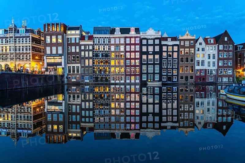 Canal houses on the Damrak, in the centre of the old town of Amsterdam, harbour, starting point of many canal tours, evening, Netherlands