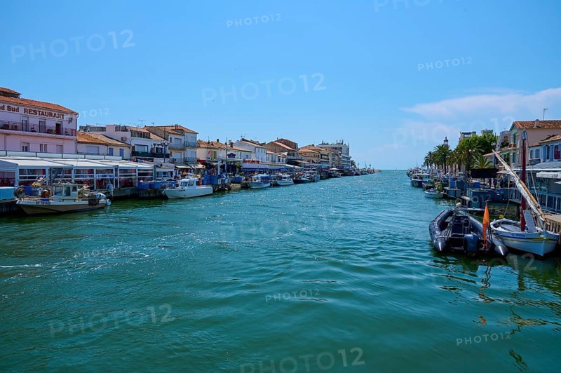 Coastal town with colourful houses, boats in the water, on a sunny day, summer, Le Grau-du-Roi, Gard, Mediterranean Sea, France, Europe