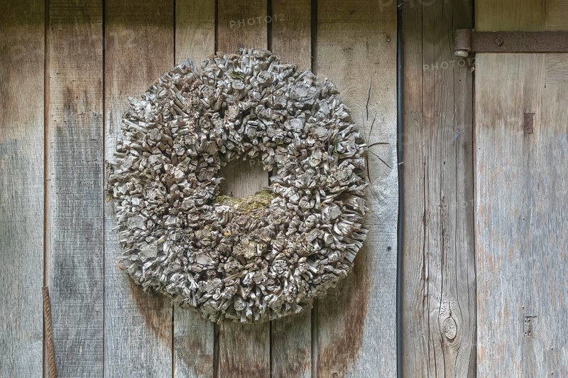 Door wreath made of natural materials in front of a house wall, North Rhine-Westphalia, Germany, Europe