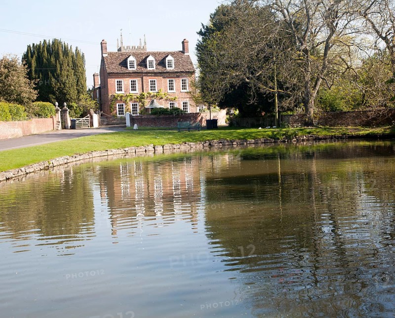 Village duck pond and historic house, in the village of Urchfont, Wiltshire, England, United Kingdom, Europe