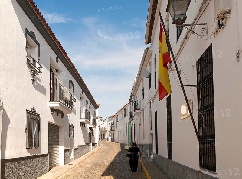 Woman walking along a quiet street in village of Jabugo, Sierra de Aracena, Huelva province, Spain, Europe