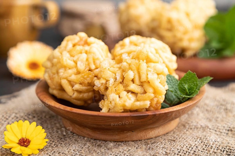 Traditional Tatar candy chak-chak made of dough and honey with cup of coffee on a black concrete background and linen textile. Side view, close up, selective focus