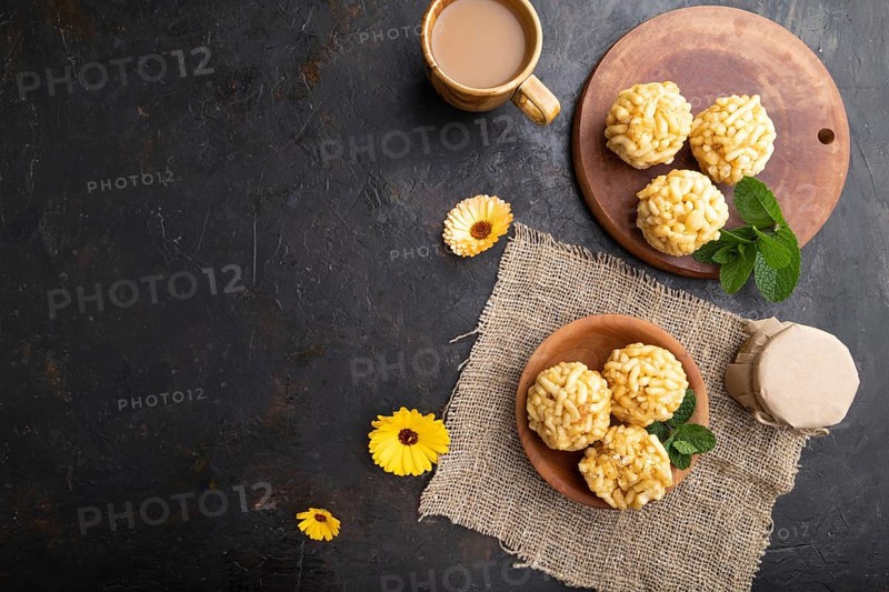 Traditional Tatar candy chak-chak made of dough and honey with cup of coffee on a black concrete background and linen textile. top view, flat lay, copy space