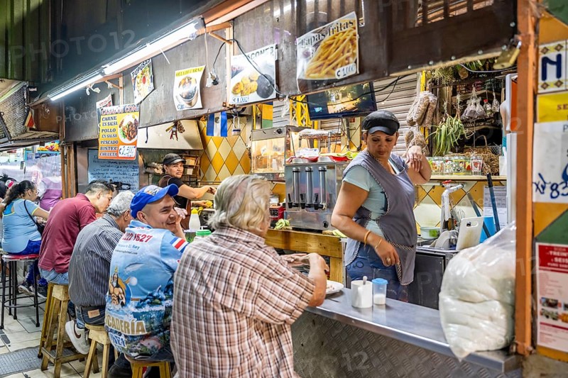 Visitors sitting at a food stall at the counter, Mercado Central de San José, San José, Costa Rica, Central America