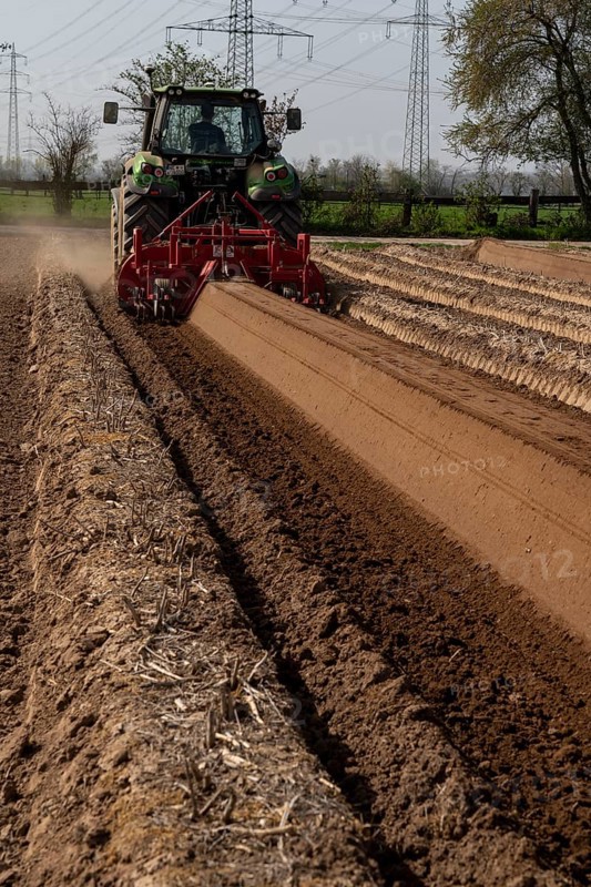 A farmer builds asparagus ridges on a field with the help of an asparagus tiller, in which the asparagus then grows, Dormagen, North Rhine-Westphalia, Germany, Europe