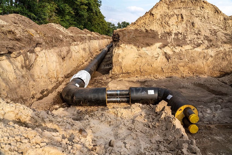 Laying of district heating pipes, next to a field, with maize, the district heating comes from a biogas plant and is fed directly into households in the neighbourhood, private provider, near Delbrück, North Rhine-Westphalia, Germany, Europe
