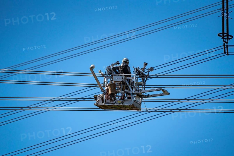 Construction of a new line route, 380 KV extra-high-voltage line between Osterath and Gohr, near Neuss, fitters in line trolleys, on the conductor cables, installing field spacers at great heights, North Rhine-Westphalia, Germany, Europe
