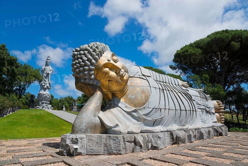 Monumental reclining Buddha statue in a green and peaceful park under a clear blue sky, Bacalhôa, Bacalhoa Buddha Eden, Quinta dos Loridos, largest oriental garden in Europe, Bombarral, Oeste, Centro, Portugal, Europe