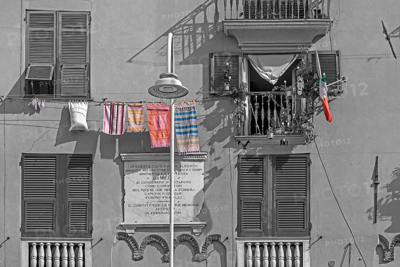 Residential building façade with green shutters and hanging laundry in the historic city centre, Genoa, Italy, Europe