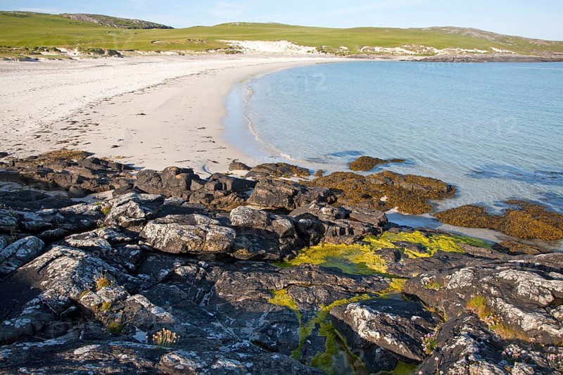 Rocky headland and sandy beach at Bagh a Deas, South Bay, Vatersay island, Barra, Outer Hebrides, Scotland, UK