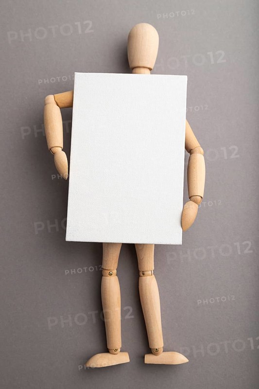 Wooden mannequin holding blank poster on gray pastel background. copy space, isolated, presentation concept