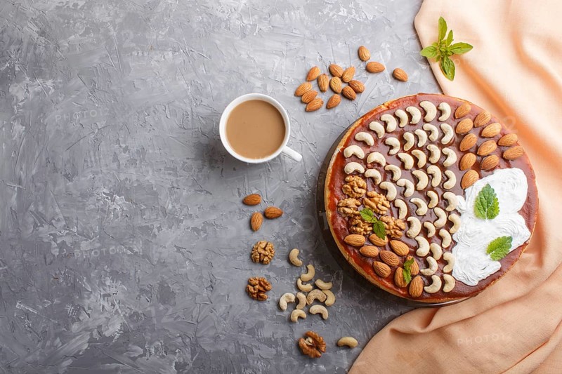 Homemade cake with caramel cream and nuts with cup of coffee on a gray concrete background. top view. flat lay, copy space