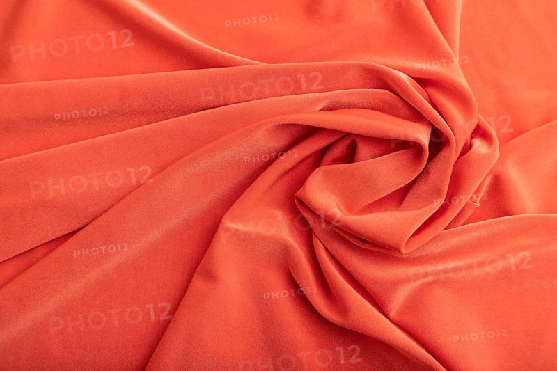 Fragment of red linen tissue. Top view, flat lay, natural textile background and texture. wave concept, abstract, spiral form