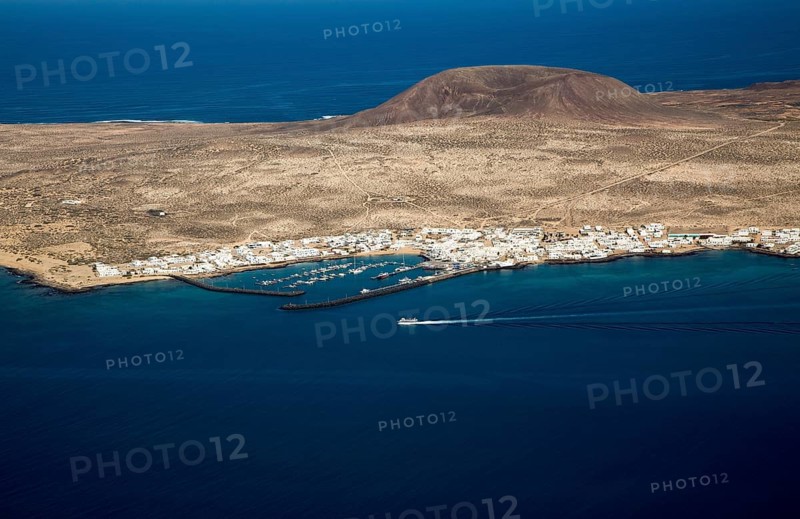 Ferry ship approaching Caleta del Sebo, La Graciosa island, Lanzarote, Canary Islands, Spain view from Mirador del Rio