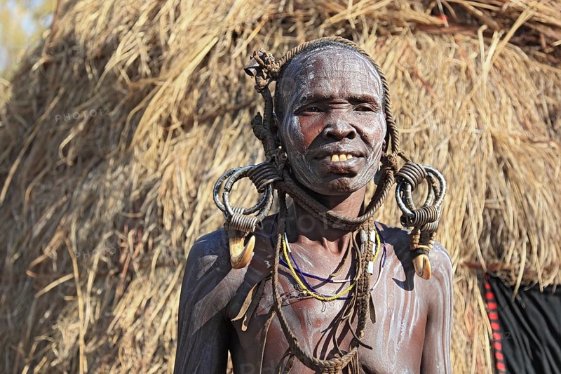 South Ethiopia, in the Maco National Park, Mursi tribe, older Mursi woman with naked upper body and painted skin and earrings, Ethiopia, Africa