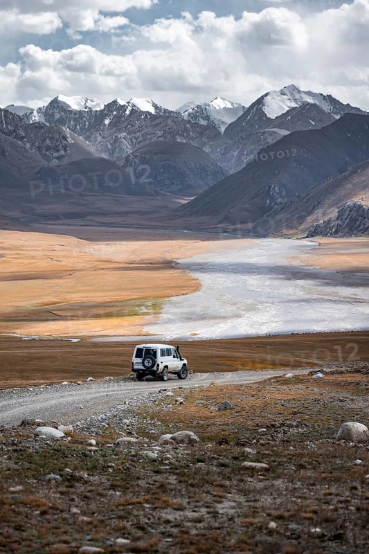 Off-road vehicle on a gravel track, glaciated and snow-covered peaks, Ak Shyrak Mountains, near Kumtor, Kara-Say, Tian Shan, Kyrgyzstan, Asia