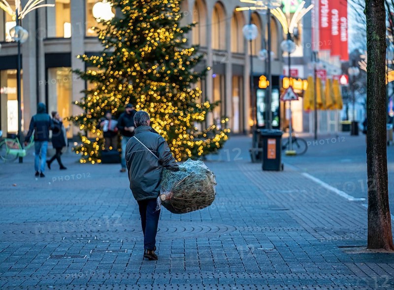 First day of the Christmas lockdown in the Corona crisis, shopping alleyway Schildergasse, woman carrying a Christmas tree through the empty alleyway, in Cologne, North Rhine-Westphalia, Germany, Europe