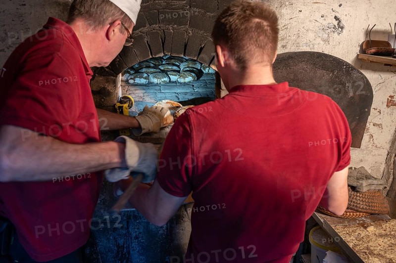 Freshly baked wood-fired bread is taken out of the wood-fired oven, baking oven festival in Franconia, Bavaria, Germany, Europe