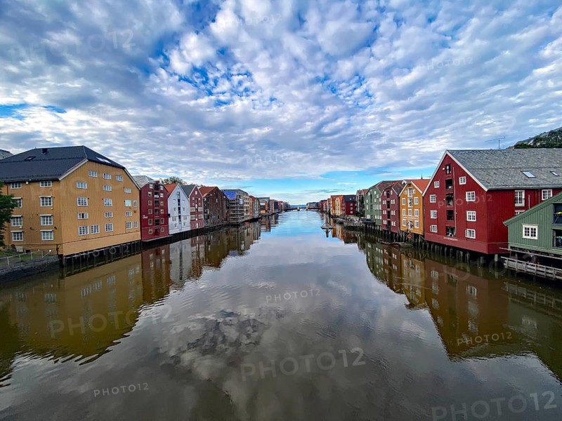 River reflecting colourful wooden buildings under a cloudy blue sky, calm atmosphere, view from the King's Bridge, Nidarelva, Trondheim, Tröndelag, Norway, Europe