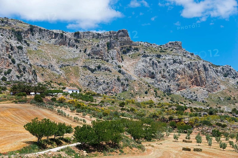 Barren rocky landscape with a small farmhouse surrounded by fields under a clear sky, nature reserve, El Torcal de Antequera, Sierra del Torcal, Málaga province, Malaga, Andalusia, Spain, Europe