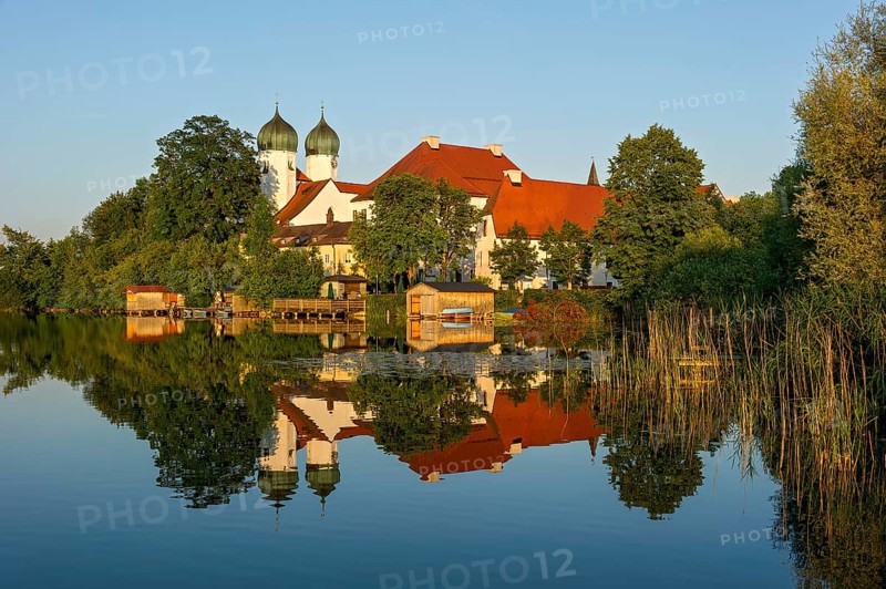 Romanesque Benedictine Abbey Seeon Monastery, monastery church St. Lambert with reflection in the monastery lake, calm smooth water in the evening light at sunset, Seeon-Seebruck, Chiemgau, Upper Bavaria, Bavaria, Germany, Europe