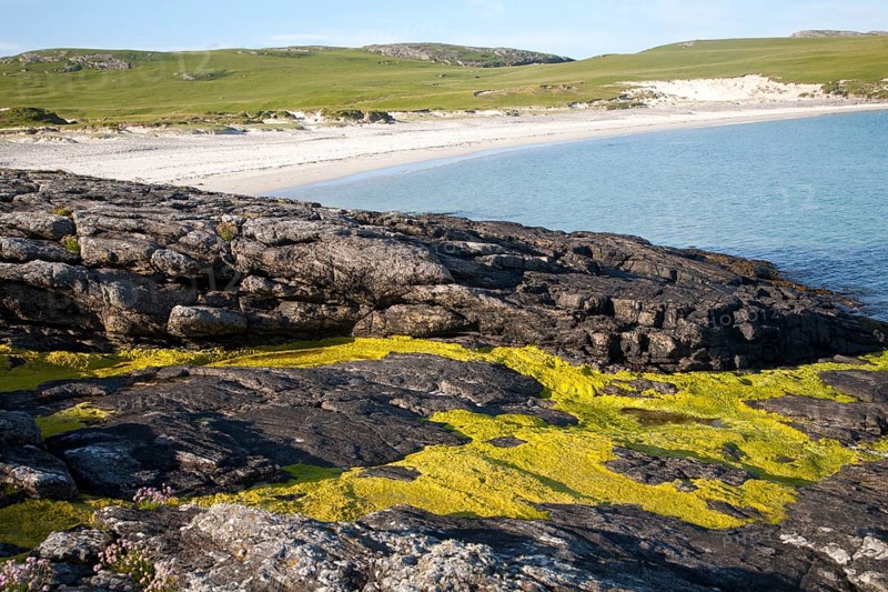 Rocky headland and sandy beach at Bagh a Deas, South Bay, Vatersay island, Barra, Outer Hebrides, Scotland, UK