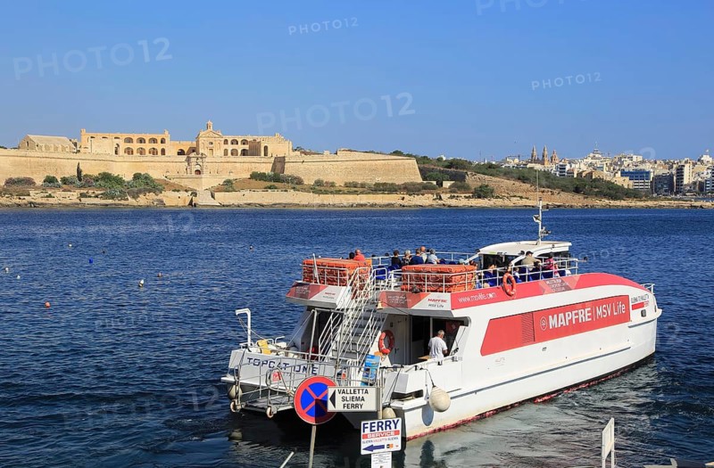 Mapfre Topcat ferry boat crossing harbour from Valletta to Sliema, Malta passing Fort Manoel