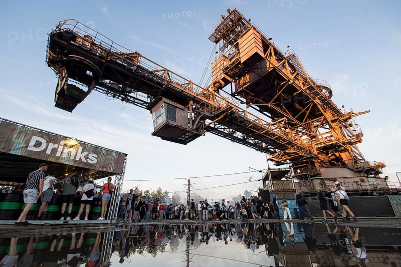 An open-cast mining excavator is reflected in a puddle at the Melt Festival in Ferropolis on 13 July 2024. After a total of 27 years, the festival will take place for the last time in 2024