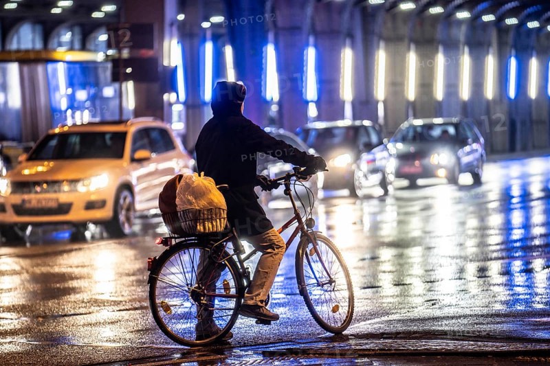 Street at the central station, cyclist, rainy weather, city centre, in the evening, Essen, North Rhine-Westphalia, Germany, Europe