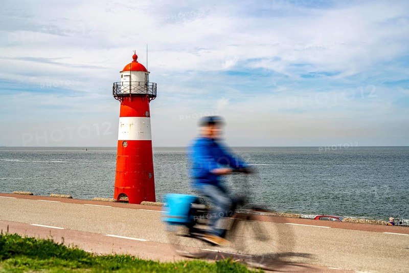 North Sea dyke near Westkapelle, Westkapelle Laag lighthouse, cyclists on the Zeeuwse Wind Route cycle path, province of Zeeland, Walcheren peninsula, Netherlands