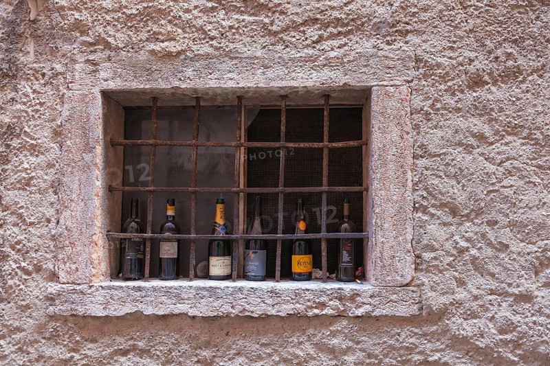 Barred window with empty champagne and wine bottles, Malcesine, Lake Garda, Province of Verona, Italy, Europe