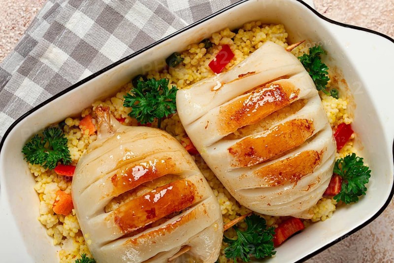 Stuffed squid carcasses, baked in the oven, fried, with couscous, top view, homemade, no people