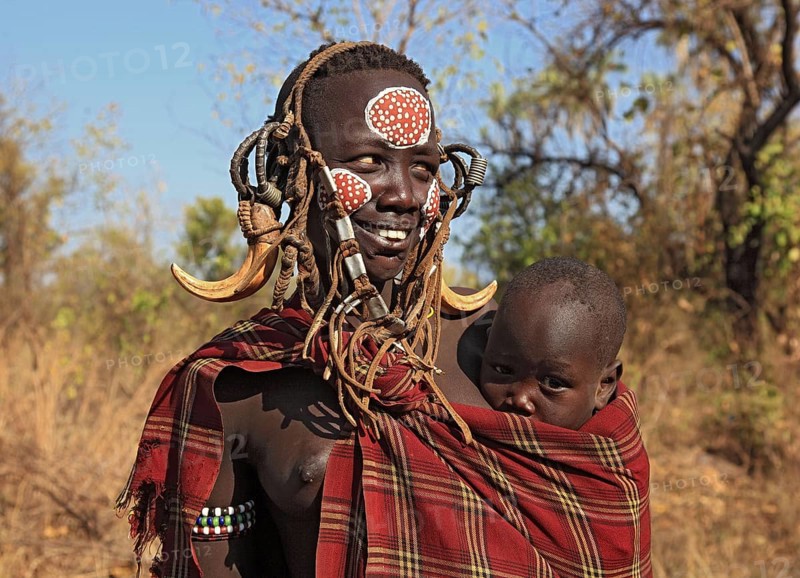 South Ethiopia, in Maco National Park, Mursi tribe, Mursi woman with baby, painted skin and headdress, Ethiopia, Africa