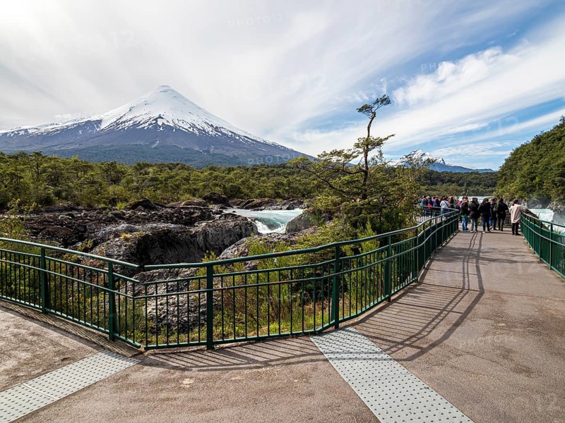 Visitors at the waterfall Saltos de Petrohue, volcano Osorno in the back, chilenean lake district, Chile, South America